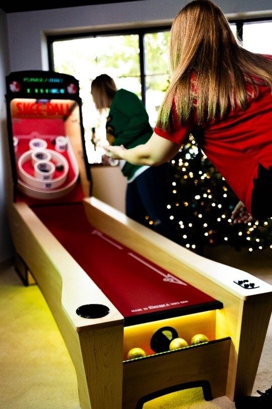 Two people play Skee-Ball at home